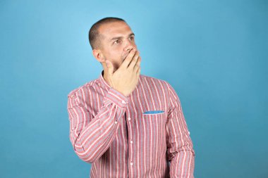 Rus iş adamı mavi arka planda korku, korku ve heyecan dolu yüz ifadesiyle korkmuş ve şok olmuştu..