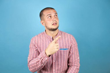 Rus iş adamı mavi arka planda afalladı ve başparmağını kaldırdı..