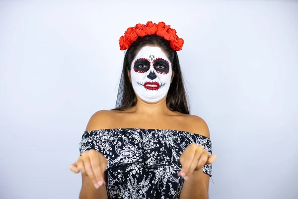 Woman wearing day of the dead costume over isolated white background disgusted expression, displeased and fearful doing disgust face because aversion reaction. With hands raised. Annoying concept