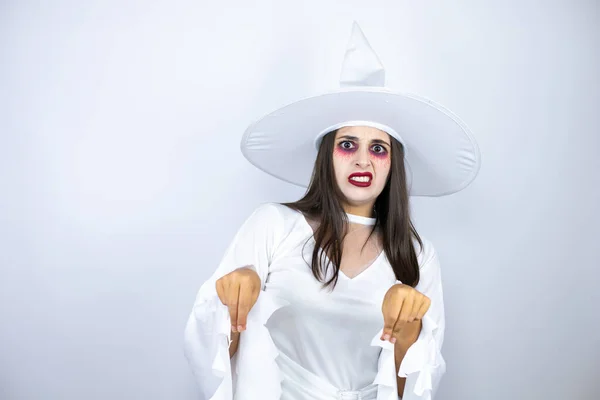 Woman wearing witch costume over isolated white background disgusted expression, displeased and fearful doing disgust face because aversion reaction. With hands raised. Annoying concept