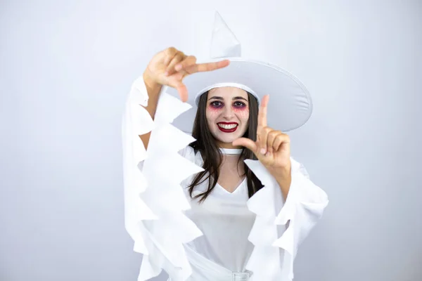 女性身に着けている魔女衣装上の隔離された白い背景笑顔フレームで手と指で幸せな顔 — ストック写真