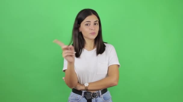 Tânără Femeie Frumoasă Peste Fundal Verde Izolat Sceptic Spunând Degetele — Videoclip de stoc