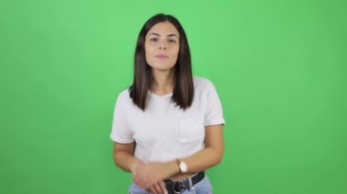 Hey sen! Kahverengi saçlı, kazaklı mutlu bir kız. Heyecanla gülümseyip kamerayı işaret ediyor. Güzellik, şanslı kazananı seçiyor. Yeşil arka planda izole edilmiş kapalı stüdyo çekimi