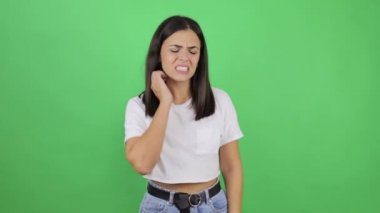 Güzel bir kız yorgun görünüyor, boynu ağrıyor, kas ağrıları çekiyor, başını oynatması zor, sağlıksız hissediyor, tıbbi konsept. Yeşil arka planda kapalı stüdyo
