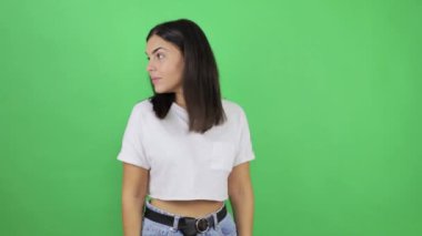 Genç, güzel bir kadın, neşeli bir şekilde gülümseyen ve göz kırpan, iyimser ve yanıltıcı bir ifadeyle tezahürat yapan, sanki yeşil arka planda bir fikri varmış gibi.