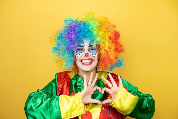 Clown Piedi Sfondo Giallo Insolato Giallo Sorridente Amore Mostrando Simbolo — Foto Stock