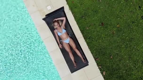 Bella donna prendere il sole presso la sua piscina, Aerea — Video Stock