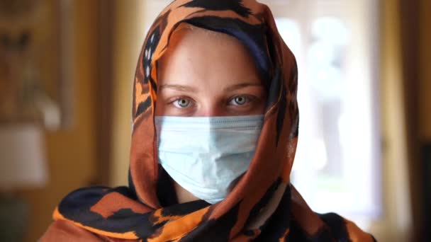 ผู้หญิงมุสลิมผิวขาวที่มีหน้ากากผ่าตัด มองไปที่กล้อง — วีดีโอสต็อก