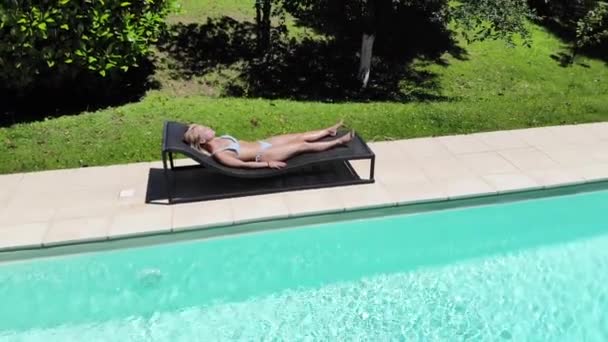 Havuzunda güneşlenen güzel bir kadın. — Stok video