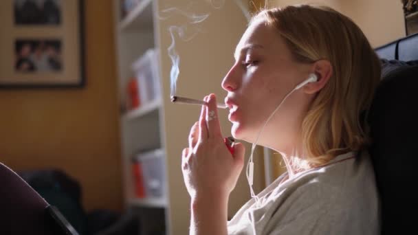 Женщина курит коноплю на закате, крупным планом — стоковое видео