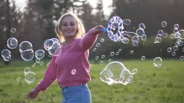 Donna felice che fa bolle nella natura al tramonto — Video Stock