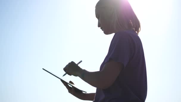 Pretty Woman skizziert mit ihrem Tablet in der Wildnis, Nahaufnahme — Stockvideo