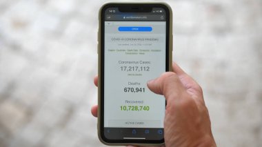 Milan, İtalya - 30 Temmuz 2020: Smartphone 'da Coronavirus Dünya Davalarına Bakılıyor