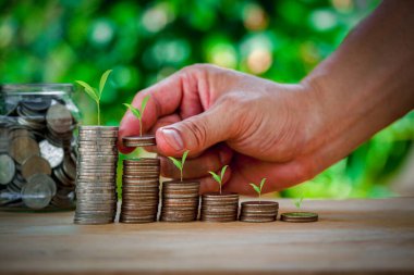 Para biriktiriyorum. Erkek el yığınları ve büyüyen konsept işi, zenginlik, eğitim, ev ve krediyi göstermek için bir kavanoz para..