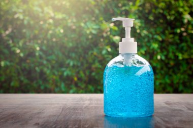 Mavi alkollü el jeli şişe pompası. El temizleme jeli ve antibakteriyel alkol masajı salgına yardımcı olabilir ve koronavirüse karşı koruma sağlar..