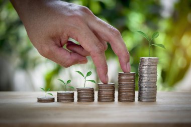 Erkek el işi sikkeler ikinci adım için aynı merdiveni istiflemek gelecek için büyümek gibi, eğitim, ev, kredi ve çocuk bokeh arka planda.