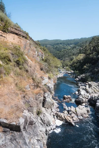 Portekiz, Arouca 'daki Paiva Nehri ve Paiva geçitlerinin muhteşem manzarası. Taşlı mavi su ve tepenin üzerinde ahşap yol.