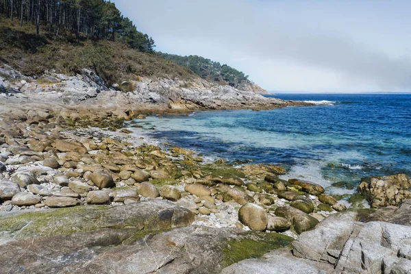 İspanya 'nın kuzeyindeki Cies takımadasındaki Monteagudo adasında turkuaz suyla huzurlu kayalık plajı.