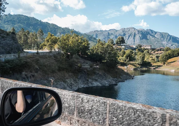 Arabanın penceresinden dışarı ve yan aynaya bak. Geres Ulusal Parkı 'ndaki Ponte Nova Köprüsü ve Cavado Nehri.