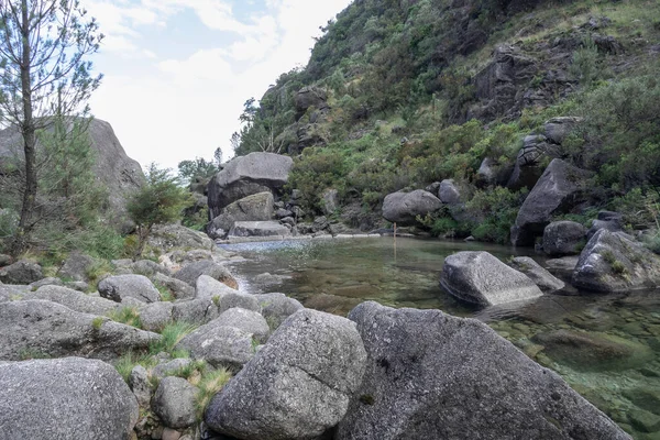 Arado nehrindeki kayalar ve bitki örtüsüyle çevrili yeşil göl, Peneda Geres Ulusal Parkı