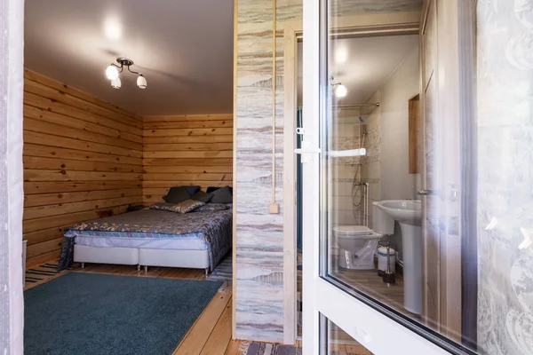 Wooden bedroom interior in mountain summer resort. Big windows, open doors