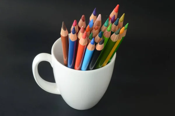 color pencils on white mug, back to school material, back to school, color pencils on dark background
