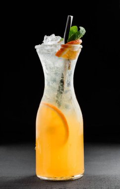 Nane, portakal ve buz cam koyu arka plan üzerinde taze turuncu limonata. Yaz içecekler ve kokteyller