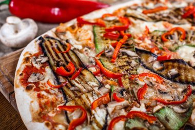 Tavuk, kabak, patlıcan, biber, peynir ve ahşap rustik masa üzerinde meyveleri lezzetli pizza. Üstten görünüm. Tonlama