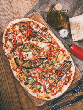 Tavuk, kabak, patlıcan, biber, peynir ve ahşap rustik masa üzerinde meyveleri lezzetli pizza. Üstten görünüm. Tonlama