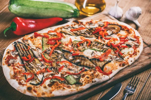 Tavuk, kabak, patlıcan, biber, peynir ve ahşap rustik masa üzerinde meyveleri lezzetli pizza. Üstten görünüm. Tonlama