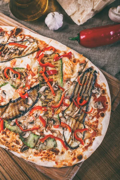 Tavuk, kabak, patlıcan, biber, peynir ve ahşap rustik masa üzerinde meyveleri lezzetli pizza. Üstten görünüm. Tonlama