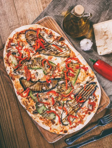 Tavuk, kabak, patlıcan, biber, peynir ve ahşap rustik masa üzerinde meyveleri lezzetli pizza. Üstten görünüm. Tonlama