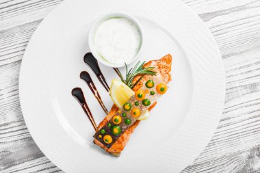 Peynir soslu somon balığı fırında, biberiye ve limon ahşap zemin üzerine kapatalım. Sıcak balık yemek