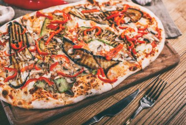 Tavuk, kabak, patlıcan, biber, peynir ve ahşap rustik masa üzerinde meyveleri lezzetli pizza. Üstten görünüm. Tonlama