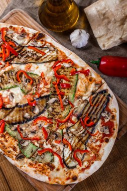 Tavuk, kabak, patlıcan, biber, peynir ve ahşap rustik masa üzerinde meyveleri lezzetli pizza. Üstten görünüm. Tonlama