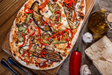 Tavuk, kabak, patlıcan, biber, peynir ve ahşap rustik masa üzerinde meyveleri lezzetli pizza. Üstten görünüm. Tonlama