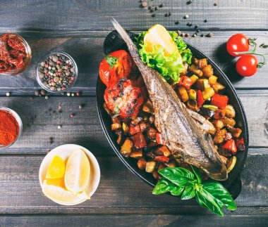 Dorado Balık Fırında sebze ve limon ahşap arka plan üzerinde Pan ile kapatın. Lezzetli yemek deniz ürünleri. «Ana sayfa» görünümü, tonlama