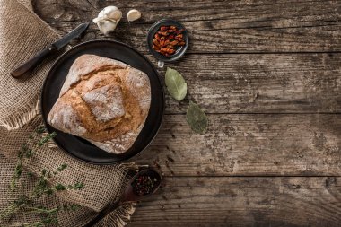 Taze ekmek ve baharat rustik ahşap arka plan üzerinde plaka üzerinde. Yaratıcı düzen ekmek yaptım. Sağlıklı gıda kavramı, üstten görünüm, düz yatıyordu, kopyalama alanı