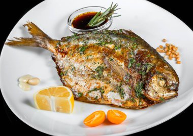 Yeşil ve siyah arka planda izole limon ile ızgara dorado balık. Sağlıklı gıda. Üstten görünüm.