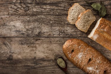 Farklı taze ekmek ve baharat rustik ahşap zemin üzerinde. Yaratıcı düzen ekmek yaptım. Sağlıklı gıda kavramı, üstten görünüm, düz yatıyordu, kopyalama alanı
