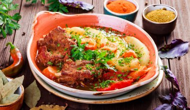 Pişmiş et ızgara sebze, patates, yeşillik plaka üzerinde ahşap arka plan ile. Sıcak et yemekleri.