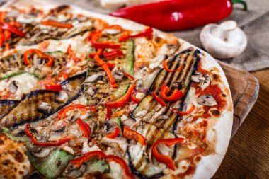 Tavuk, kabak, patlıcan, biber, peynir ve ahşap rustik masa üzerinde meyveleri lezzetli pizza. Üstten görünüm. Tonlama.