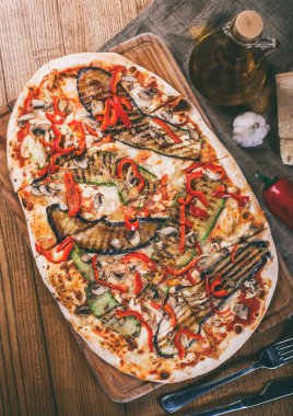 Tavuk, kabak, patlıcan, biber, peynir ve ahşap rustik masa üzerinde meyveleri lezzetli pizza. Üstten görünüm. Tonlama.