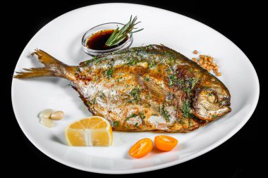 Yeşil ve siyah arka planda izole limon ile ızgara dorado balık. Sağlıklı gıda. Üstten görünüm.