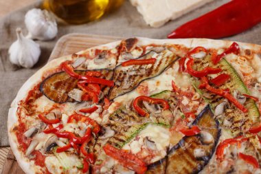 Tavuk, kabak, patlıcan, biber, peynir ve ahşap rustik masa üzerinde meyveleri lezzetli pizza. Üstten görünüm. Tonlama.