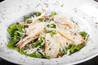 Tavuk göğsü, parmesan peyniri, kruton, karışık yeşillik, ahşap arka plan üzerinde marul salatası. Sağlıklı gıda. Maddeler tablosundaki