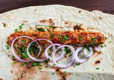 Tavuk kebap Pide, soğan ve koyu ahşap zemin üzerine yeşil. Şaşlık veya şiş kebap. Sağlıklı yemek.