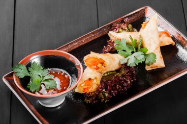 Sebze ve sos plaka üzerinde koyu ahşap arka plan ile doldurulmuş krep. Sağlıklı kahvaltı. Üstten görünüm.