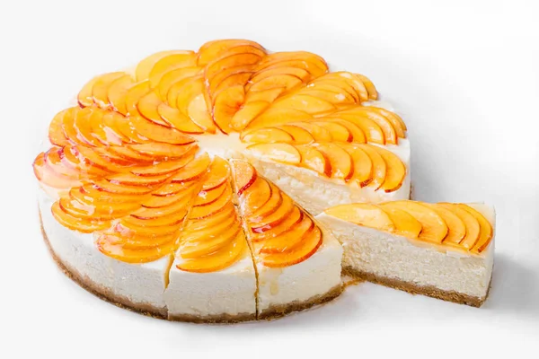 Cheese cake with peach slices isolated on white background.