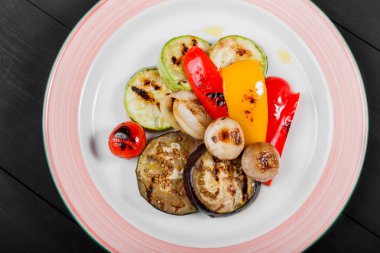 Izgara vagetables, mantar, domates, patlıcan ahşap arka plan üzerinde plaka üzerinde. Sağlıklı gıda.